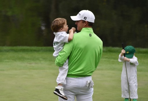 US golfer Jimmy Walker holds is son on the 9th green during the Par 3 contest prior to the start of the 80th Masters of Tournament at the Augusta National Golf Club on April 6, 2016, in Augusta, Georgia. / AFP PHOTO / Nicholas Kamm