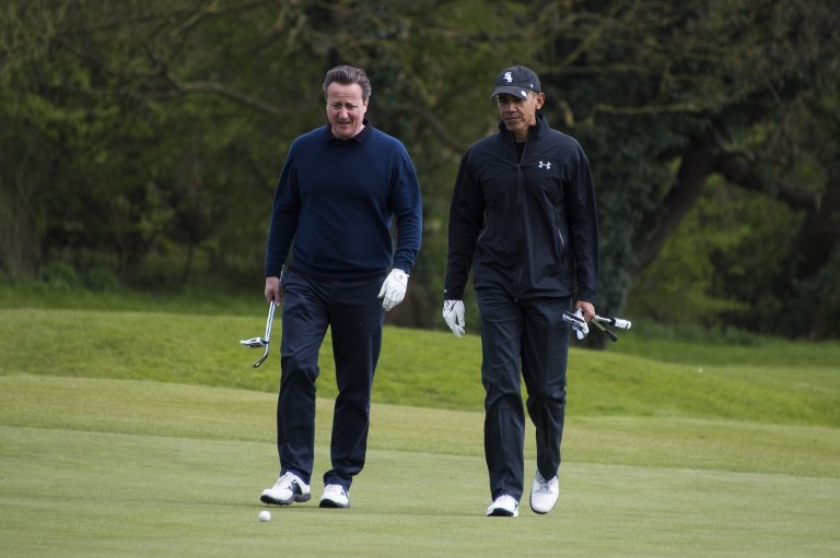 US President Barack Obama (R) talks with British Prime Minister David Cameron (L) as they walk onto the 3rd green at The Grove Golf Course near Watford in Hertfordshire, north of London, on April 23, 2016. / AFP PHOTO / Jim Watson