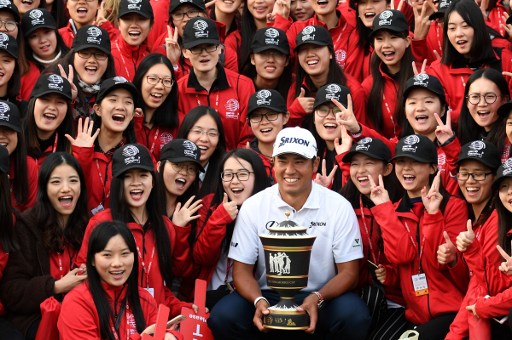 Hideki Matsuyama (C) of Japan poses with the winner's trophy after the final round of the World Golf Championships-HSBC Champions golf tournament in Shanghai on October 30, 2016. / AFP PHOTO / JOHANNES EISELE