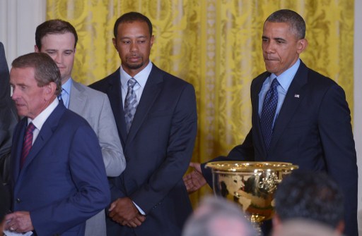 US President Barack Obama (R) walks past golfer Tiger Woods (R) as he arrives for an event honoring the 2013 Presidents Cup golf teams on June 24, 2014 in the East Room of the White House in Washington, DC. Looking on are PGA Commissioner Tim Finchem (L) and golfer Zach Johnson (2L). AFP PHOTO/Mandel NGAN / AFP PHOTO / MANDEL NGAN