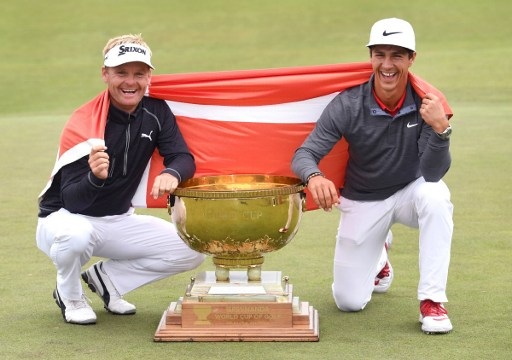 Soren Kjeldsen (L) and Thorbjorn Olesen (R) of Denmark pose with the trophy after winning the World Cup of Golf on the Kingston Heath course in Melbourne on November 27, 2016. / AFP PHOTO / WILLIAM WEST / --IMAGE RESTRICTED TO EDITORIAL USE - STRICTLY NO COMMERCIAL USE--