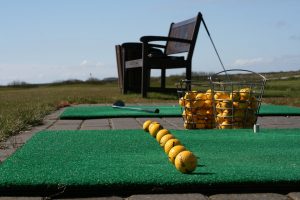 Palline da golf in fila in un campo di pratica