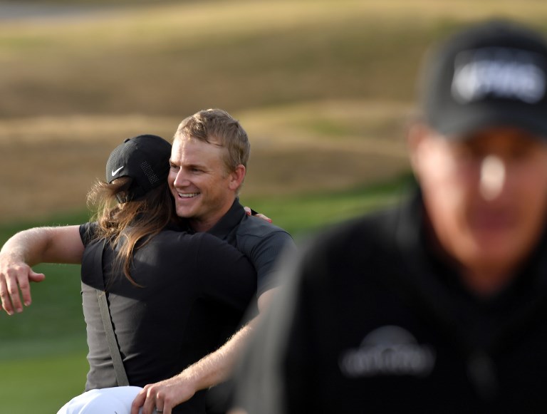 LA QUINTA Adam Long festeggia con la moglie Emily la prima vittoria sul PGA Tour. Davanti a loro Phil Mickelson (Foto Donald Miralle/Getty Images/AFP).