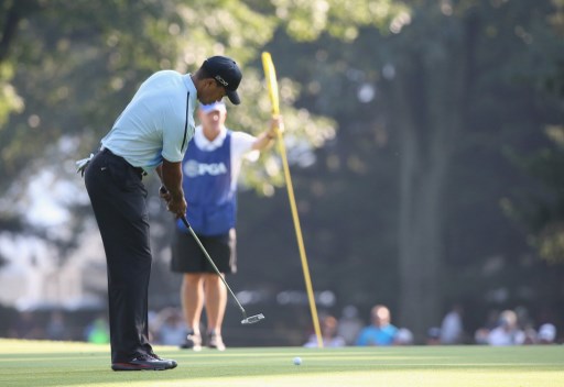 ROCHESTER Un Tiger Woods d'annata putta col suo caddie dell'epoca Joe LaCava che custodisce l'asta dentro la buca nell'edizione 2013 del PGA Championship (foto Rob Carr/Getty Images/AFP).