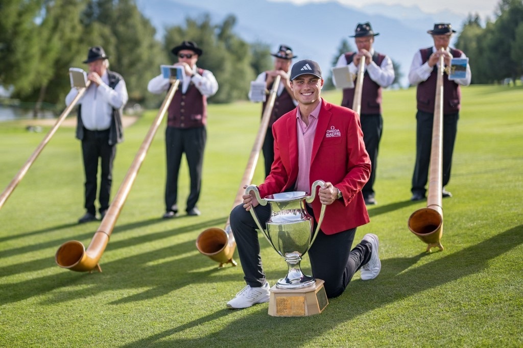 Ludvig Aberg in un momento folcloristico dopo aver vinto a Crans Montana (Foto di Fabrice COFFRINI / AFP)